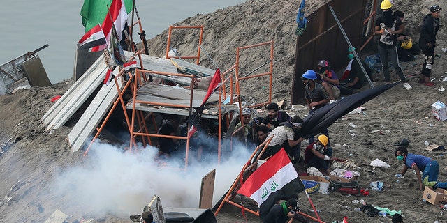 Iraqi security forces use tear gas to disperse anti-government protesters in Baghdad, Iraq, Wednesday, Oct. 30, 2019. Anti-government protests in Iraq gained momentum Wednesday with tens of thousands of people gathered in a central square in Baghdad and across much of the country's Shiite-majority central southern provinces. (AP Photo/Hadi Mizban)