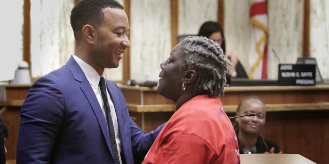 Singer songwriter John Legend, left, greets Carmen Brown who was the first person called up in a special court hearing aimed at restoring her right to vote under Florida's amendment 4, Friday, Nov. 8, 2019, in Miami.