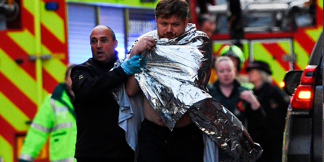 Police assist an injured man near London Bridge in London, on November 29, 2019 after reports of shots being fired on London Bridge. - The Metropolitan Police on Friday said several people were injured and a man was held after a stabbing near London Bridge in the centre of the British capital. (Photo by DANIEL SORABJI / AFP) (Photo by DANIEL SORABJI/AFP via Getty Images)