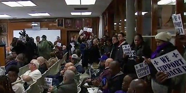 Parents with signs supporting New Rochelle High School football coach Lou DiRienzo at a meeting Thursday with school superintendent Laura Feijoo.