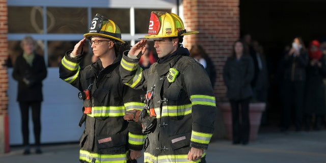 Two Firefighters salute at Grove Street Fire Station, after putting the flag at half staff after Lt. Jason Menard died in an overnight fire Wednesday, Nov. 13, 2019 in Worcester, Mass.