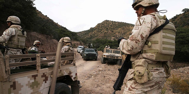 Heavily armed Mexican authorities guarded a caravan of friends and relatives as they arrived at the site where nine Americans were gunned down on Monday. (AP Photo/Marco Ugarte)
