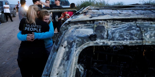 Relatives of slain members of Mexican-American families belonging to Mormon communities react next to the burnt wreckage of a vehicle where some of their relatives died in Sonora state. 
