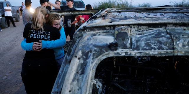 Relatives of slain members of Mexican-American families belonging to Mormon communities react next to the burnt wreckage of a vehicle where some of their relatives died in Sonora state. 