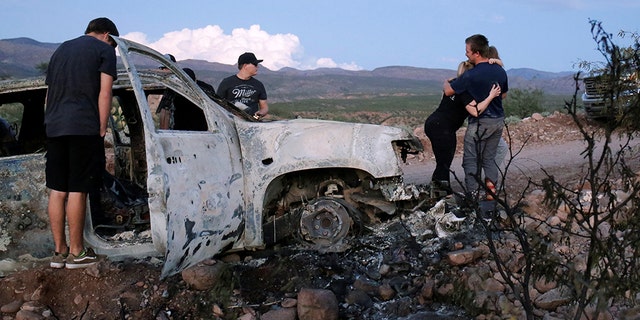 Relatives of the innocent victims observe the wreckage of a burn-out car where several members of a family were found shot and burned to death. November 5, 2019. 