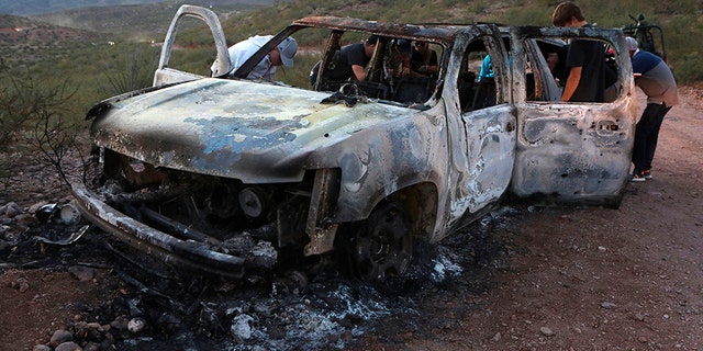 Members of the Lebaron family watch the burned car where part of the nine murdered members of the family were killed and burned during an gunmen ambush on Bavispe, Sonora mountains, Mexico, on November 5, 2019. - US President Donald Trump offered Tuesday to help Mexico 