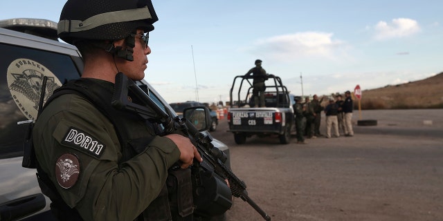 Chihuahua state police officers man a checkpoint in Janos, Chihuahua state, northern Mexico, Tuesday, Nov. 5, 2019. Drug cartel gunmen ambushed three SUVs along a dirt road, slaughtering six children and three women, all U.S. citizens living in northern Mexico, in a grisly attack that left one vehicle a burned-out, bullet-riddled hulk, authorities said Tuesday. (AP Photo/Christian Chavez)