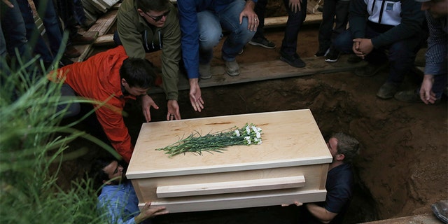 The coffin that contains the remains of 12-year-old Howard Jacob Miller Jr. is lowered into a grave at the cemetery in Colonia Le Baron, Mexico, on Nov. 8, during a burial service for Rhonita Miller and four of her young children who were murdered by drug cartel gunmen.