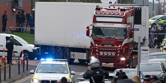 Police escort the truck that was found to contain the bodies away from an industrial area in Thurrock, south England.