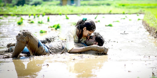 The series of photos showed the couple smiling and cuddling while laying down in a muddy pool of water in a grassy countryside.