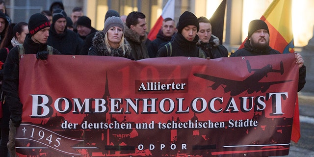 Right-wing extremists hold up a banner reading 'Alliierter Bombenholocaust' (lit. 'Allied Bombing Holocaust') during a so-called funeral march in Dresden, Germany, 11 February 2017. (Photo by Sebastian Kahnert/picture alliance via Getty Images)