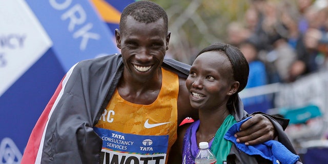 In this Nov. 1, 2015, file photo, Stanley Biwott, left, embraces fellow Kenyan Mary Keitany after the pair won the men's and women's divisions in the New York City marathon. Mary Keitany is back for another bolt through the boroughs.