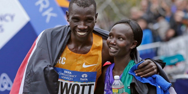 In this Nov. 1, 2015, file photo, Stanley Biwott, left, embraces fellow Kenyan Mary Keitany after the pair won the men's and women's divisions in the New York City marathon. Mary Keitany is back for another bolt through the boroughs.