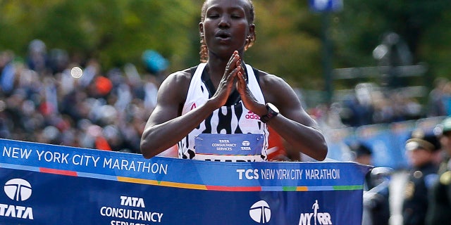 In this Nov. 2, 2014, file photo, Mary Keitany, of Kenya, puts her hands together as she breaks the tape after winning the elite women's division in the the 44th annual New York City Marathon in New York.