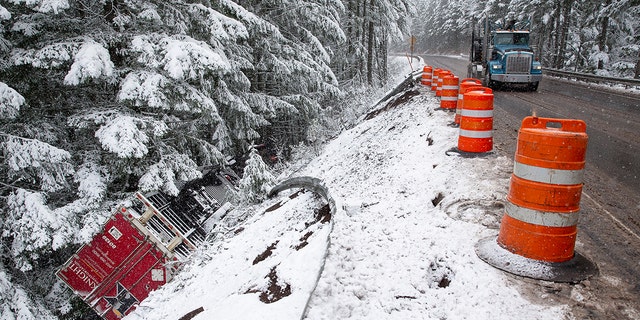 A tractor-trailer flipped over on Highway 58, easterly of Oakridge, Ore., underneath snowy and breezy conditions Monday.