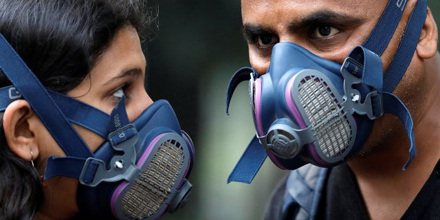 People wear masks on a smoggy evening in New Delhi, India, October 31, 2019. REUTERS/Anushree Fadnavis - RC1AF59327B0