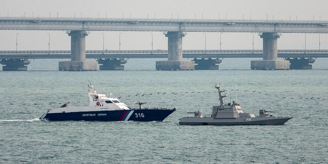 A seized Ukrainian ship is towed by a Russian Coast Guard vessel out of the port in Kerch, near the bridge connecting the Russian mainland with the Crimean Peninsula, Crimea on Sunday. Russia said Monday that it returned three Ukranian naval ships captured last year. (Reuters/Alla Dmitrieva)