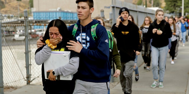 FILE - This Nov. 14, 2019 file photo shows students being escorted out of Saugus High School after a shooting on the campus in Santa Clarita, Calif.(AP Photo/Marcio Jose Sanchez, File)