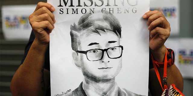 A supporter of Simon Cheng holds a poster outside of the British Consulate in Hong Kong in August during a rally in support of him. (AP)