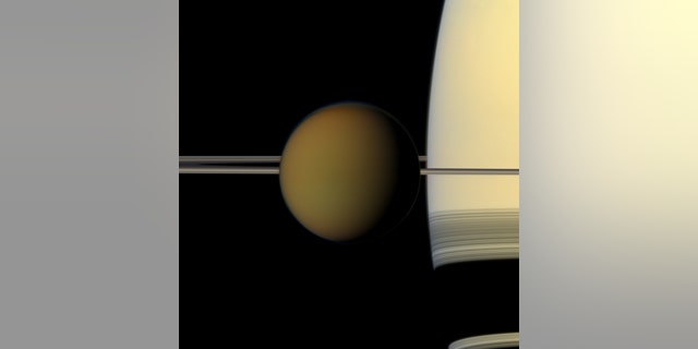 2011年，这张彩色彩色的泰坦巨球从土星及其环上经过，这张照片是NASA卡西尼号飞船的真彩色照片。图片来源：NASA / JPL-Caltech / Space Science Institute