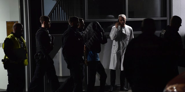 A man is arrested by the police at a hospital in Berlin, Germany after the son of former German Richard von Weizsaecker president was killed while he was giving a lecture. (Paul Zinken/dpa via AP)