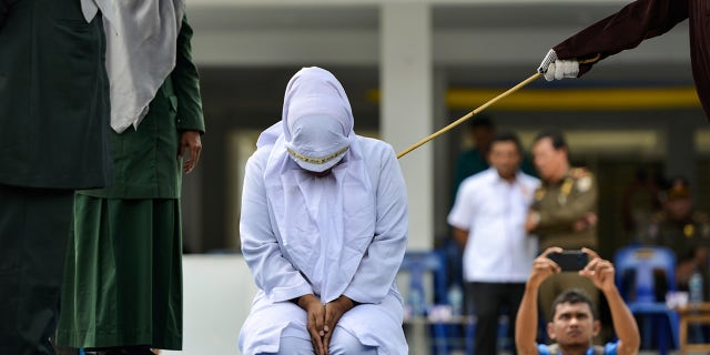 A woman is whipped in public by a member of the Sharia police in Banda Aceh on October 31, 2019, after being caught having an affair with Aceh Ulema Council (MPU) member Mukhlis.