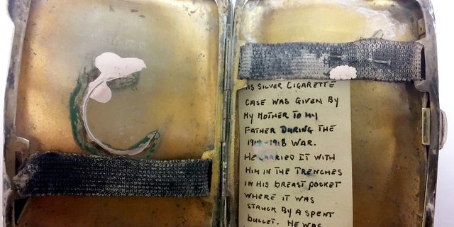 A dented and damaged silver cigarette case, which appears to have taken the full force of bullet, has been unearthed by Hansons Auctioneers – and an aging note tucked inside reveals its secrets. (Credit: SWNS)