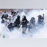Police move through a cloud of smoke as they detain a protester at the Hong Kong Polytechnic University in Hong Kong, Nov. 18, 2019. 
