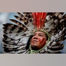 A leader of an indigenous community in Brazil wears a feather headdress as he protests against forest destruction in front of the EU headquarters in Brussels, Nov. 5, 2019.