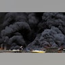 A man with a bucket stands next to smoke plumes from a market fire in downtown Lagos, Nigeria, Nov. 5, 2019.