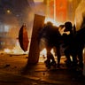 Protestors shield themselves as police fire tear gas in the Kowloon area of Hong Kong, Nov. 18, 2019. 