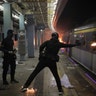 A student hurls a molotov cocktail into a train parked inside the Chinese University MTR station in Hong Kong, Nov. 13, 2019. 