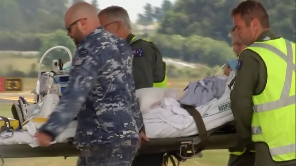 An injured tourist in the volcano eruption is carried to an Australian Air Force plane in Hamilton, New Zealand, Thursday, Dec. 12, 2019. N Australian Broadcasting Corporation via AP