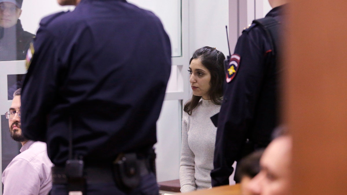 Israeli woman Naama Issachar, center, sits inside a cage during appeal hearings in a courtroom in Moscow, Russia, Thursday, Dec. 19, 2019. Naama was sentenced in October to seven and a half years in prison for drug smuggling after authorities in April found nine grams of marijuana in her luggage.