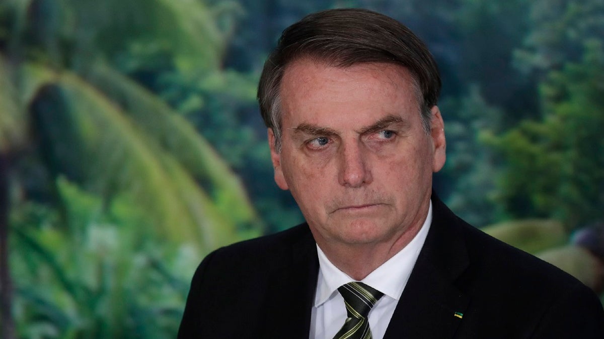 In this Oct. 1, 2019 file photo, President Jair Bolsonaro attends a ceremony to launch an agro program at the Planalto presidential palace in Brasilia, Brazil. Bolsonaro lashed out at journalists on Friday, singling out one as looking like a homosexual, as news reports of a corruption investigation linked to his son continued making headlines. (AP Photo/Eraldo Peres, File)