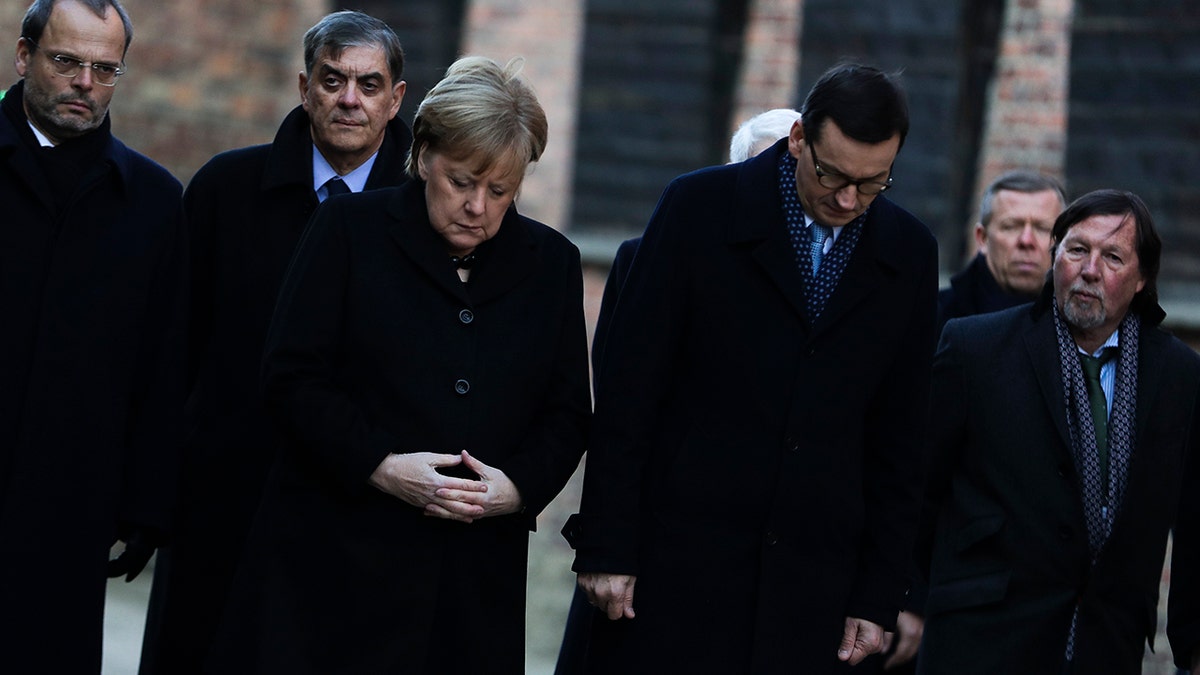 German Chancellor Angela Merkel, center left, and Polish Prime Minister Mateusz Morawiecki, center right, attend a wreath-laying ceremony at the death wall in the former Nazi death camp of Auschwitz-Birkenau in Oswiecim, Germany, Friday, Dec. 6, 2019. Merkel visits the former death camp in the occasion of the 10th anniversary of the founding of the Auschwitz Foundation.