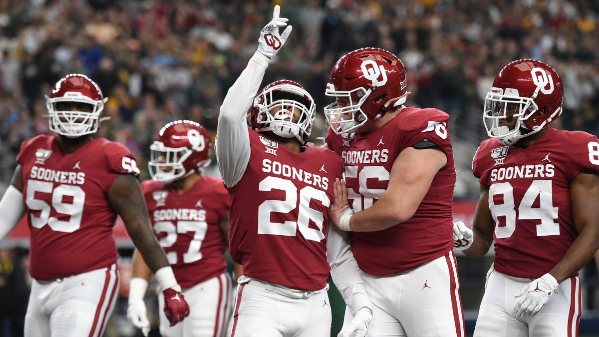 Oklahoma running back Kennedy Brooks (26) celebrates with offensive lineman Creed Humphrey (56) after rushing for a touchdown against Baylor during the first half of an NCAA college football game for the Big 12 Conference championship, Saturday, Dec. 7, 2019, in Arlington, Texas. (AP Photo/Jeffrey McWhorter)