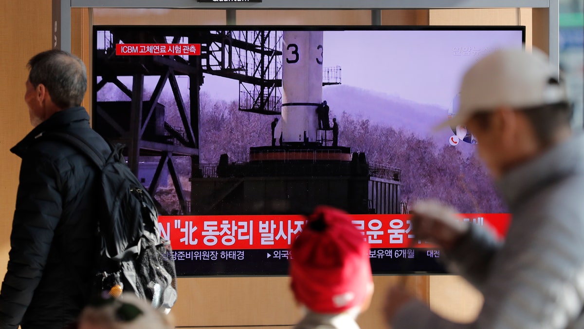 People watch a TV news program reporting North Korea's announcement with file image at the Seoul Railway Station in Seoul, South Korea, Sunday, Dec. 8, 2019. North Korea said Sunday it carried out a “very important test” at its long-range rocket launch site that it reportedly rebuilt after having partially dismantled it after entering denuclearization talks with the United States last year. The part of letters read "North. Tongchang-ri." (AP Photo/Lee Jin-man)