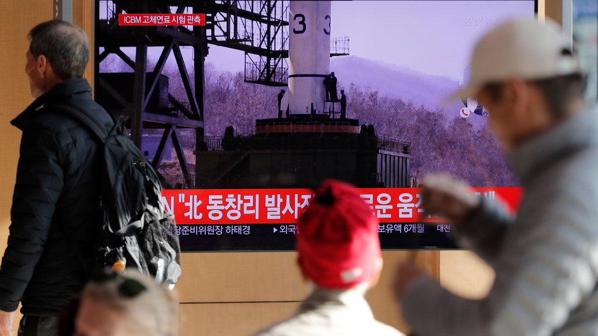 People watch a TV news program reporting North Korea's announcement with file image at the Seoul Railway Station in Seoul, South Korea, Sunday, Dec. 8, 2019. North Korea said Sunday it carried out a “very important test” at its long-range rocket launch site that it reportedly rebuilt after having partially dismantled it after entering denuclearization talks with the United States last year. The part of letters read "North. Tongchang-ri." (AP Photo/Lee Jin-man)