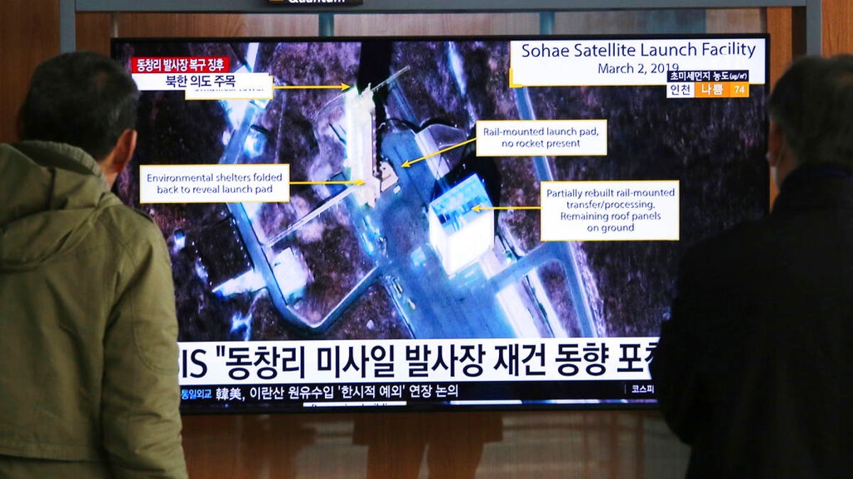 In this March 6, 2019, file photo, people watch a TV screen showing an image of the Sohae Satellite Launching Station in Tongchang-ri, North Korea, during a news program at the Seoul Railway Station in Seoul, South Korea. North Korea on Saturday, Dec. 14, says it successfully performed another "crucial test" as its long-range rocket launch site that would further strengthen its "reliable strategic nuclear deterrent."The signs read: " North's Tongchang-ri launch site." 