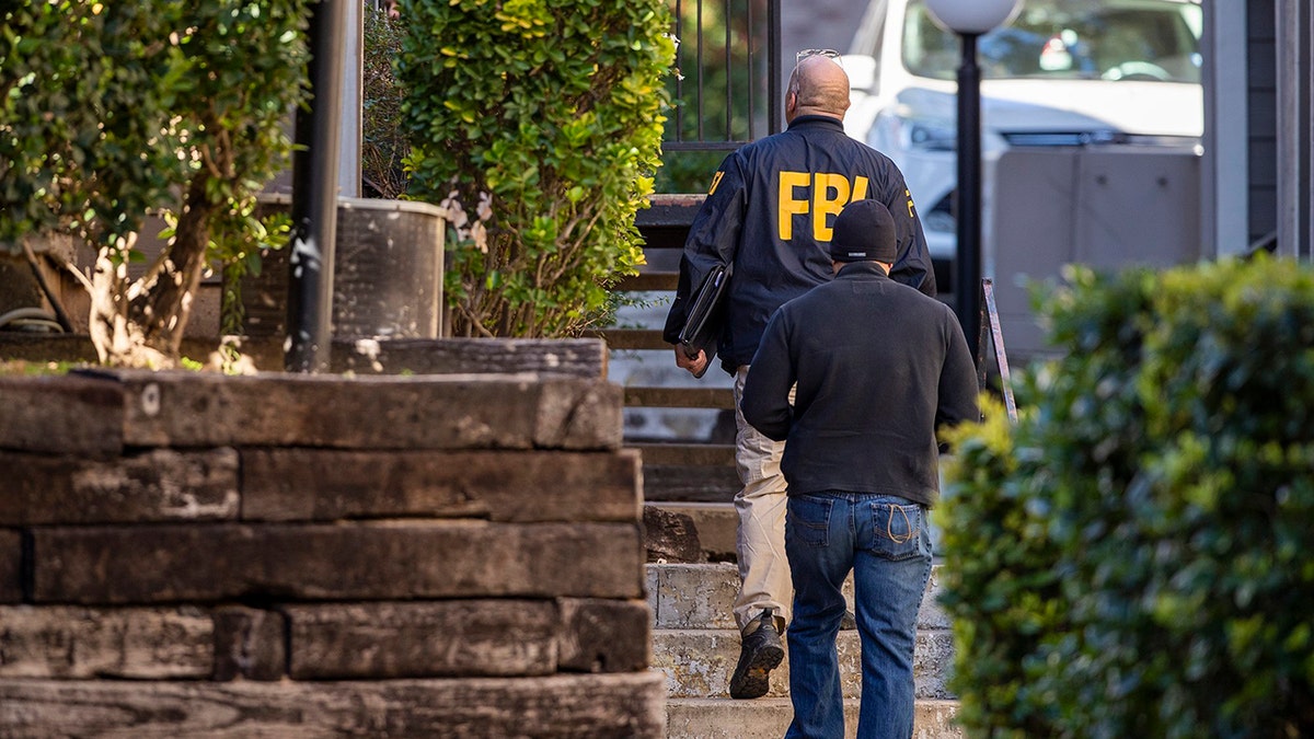 In this Wednesday, Dec. 18, 2019 photo, FBI agents canvas the neighborhood searching for information on Heidi Broussard, a missing Austin, Texas, woman and her infant daughter in South Austin, Texas. Authorities recovered a woman's body and found a child safe in a home on the outskirts of Houston. (Ricardo B. Brazziell/Austin American-Statesman via AP)