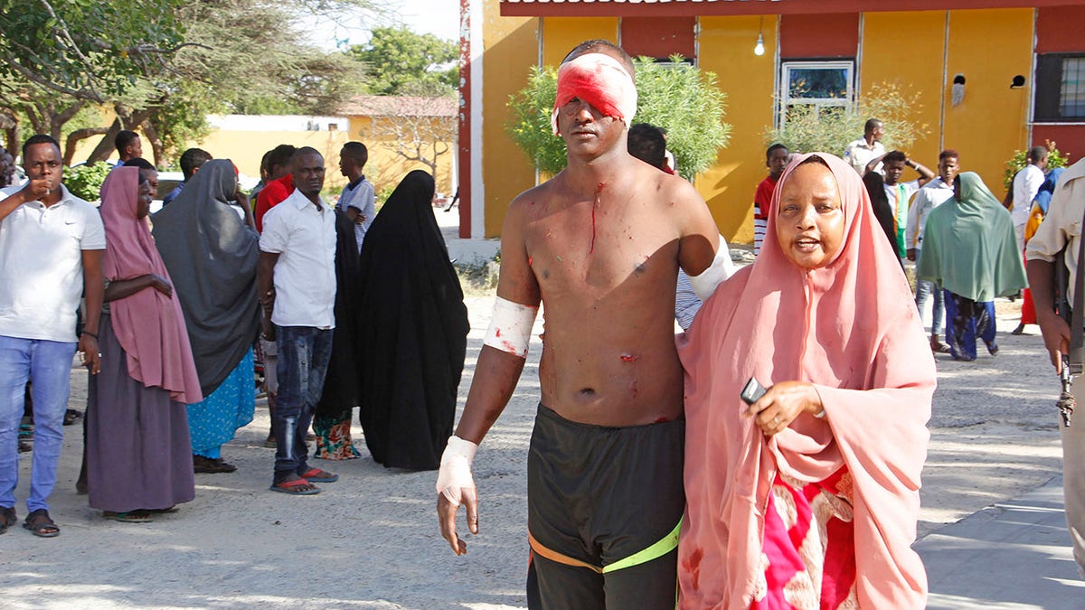 A civilian who was wounded in a suicide car bomb attack is helped at checkpoint in Mogadishu, Somalia, Saturday, Dec, 28, 2019. (Associated Press)