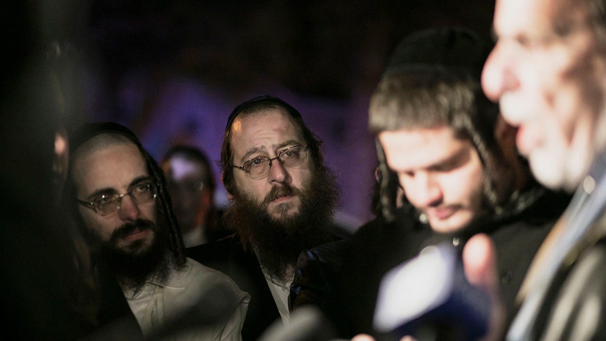 Orthodox Jewish people listen to N.Y. state Assemblyman Dov Hikind speak in Monsey, N.Y., Sunday, Dec. 29, 2019, following a stabbing late Saturday during a Hanukkah celebration. A man attacked the celebration at a rabbi's home north of New York City late Saturday, stabbing and wounding several people before fleeing in a vehicle, police said. (Associated Press)