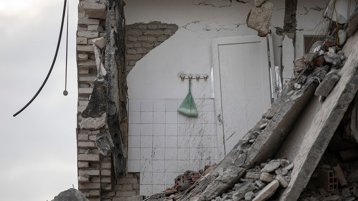 In this Wednesday, Nov. 27, 2019, a plastic bag with washing powder hangs on a wall of a collapsed building in Thumane, western Albania following a deadly earthquake.
