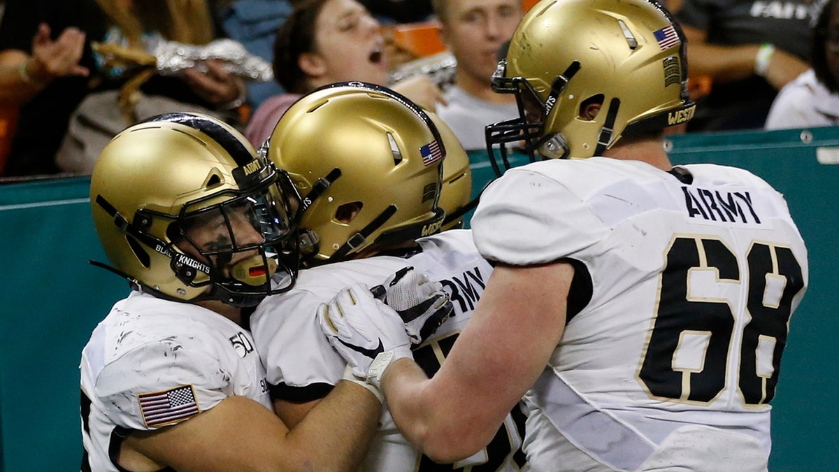 Army running back Connor Slomka (25) celebrates with teammates after making a touchdown against Hawaii during the second half of an NCAA college football game Saturday, Nov. 30, 2019 in Honolulu. (AP Photo/Marco Garcia)