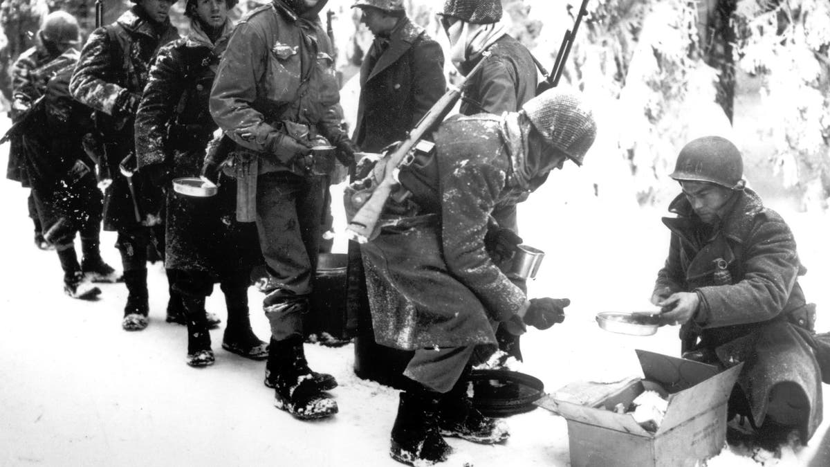 FILE - In this Jan. 13, 1945 file photo, and provided by the U.S. Army, American soldiers of the 347th U.S. Infantry wear heavy winter gear as they receive rations in La Roche, Belgium.