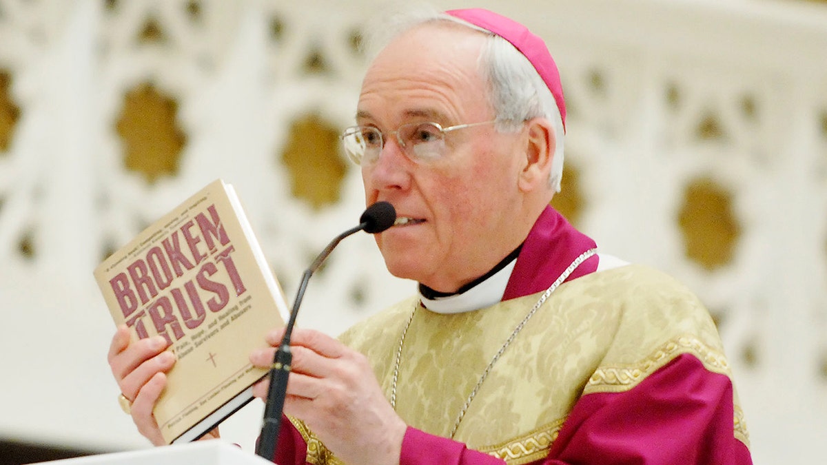 Bishop Richard Malone holds up a copy of the book "Broken Trust" during his homily Thursday, May 29, 2008, at a mass of prayer and penance for harm done to survivors and faithful by past incidents of clergy sexual abuse.