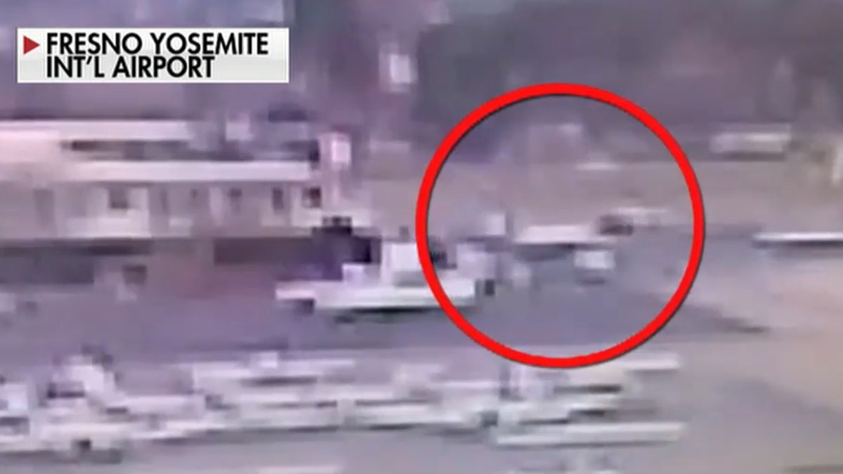 A grainy surveillance video shows the aircraft crashing into a fence and a building.