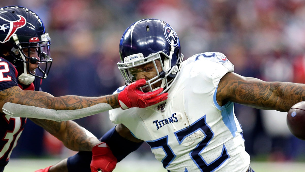 Houston Texans cornerback Lonnie Johnson (32) reaches to tackle Tennessee Titans running back Derrick Henry (22) during the first half of an NFL football game Sunday, Dec. 29, 2019, in Houston. (AP Photo/Michael Wyke)