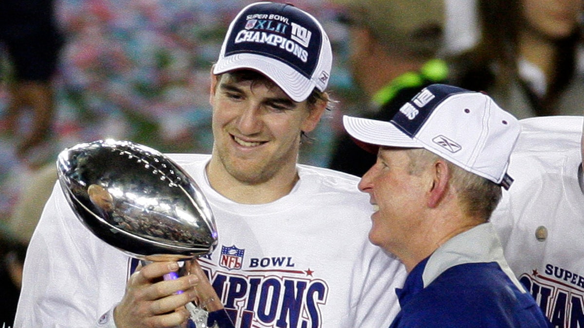 New York Giants quarterback Eli Manning, left, and his coach Tom Coughlin looking at the Vince Lombardi Trophy as they celebrate after the Giants beat the New England Patriots 17-14 in the Super Bowl XLII on Feb. 3, 2008, in Glendale, Arizona.